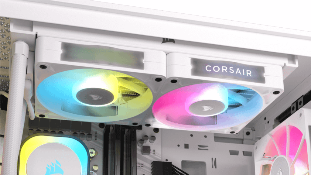 A modern PC setup showcasing three vibrant Corsair iCUE LINK RX Series fans mounted within a white case, illuminating the interior with a spectrum of RGB colors
